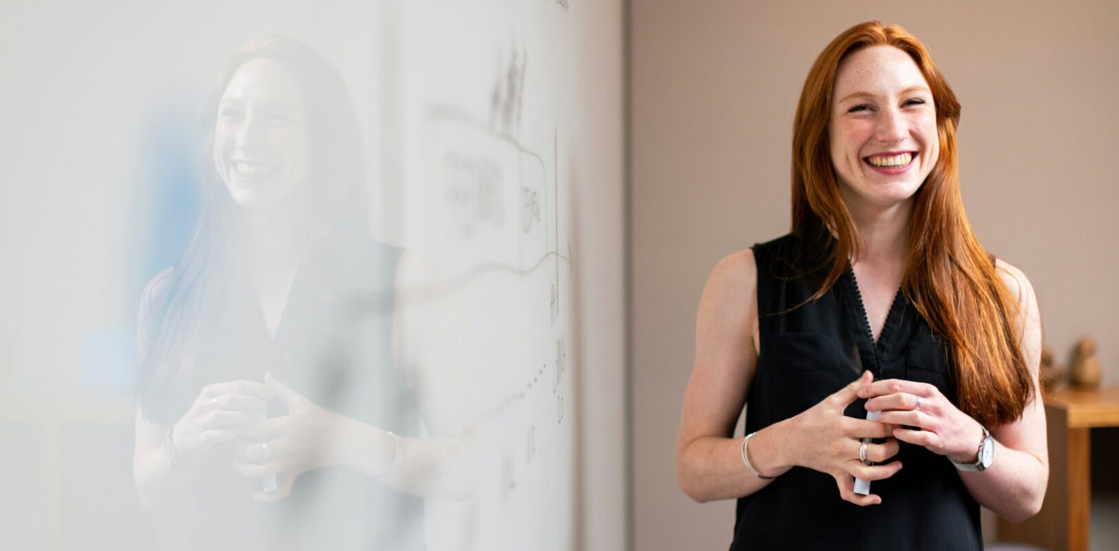 rödhårig kvinnlig ingenjör står vid whiteboard