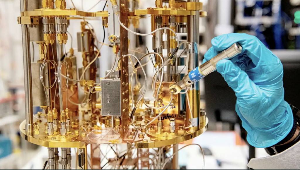 Närbild kvantdator med hand iklädd blå labbhandske