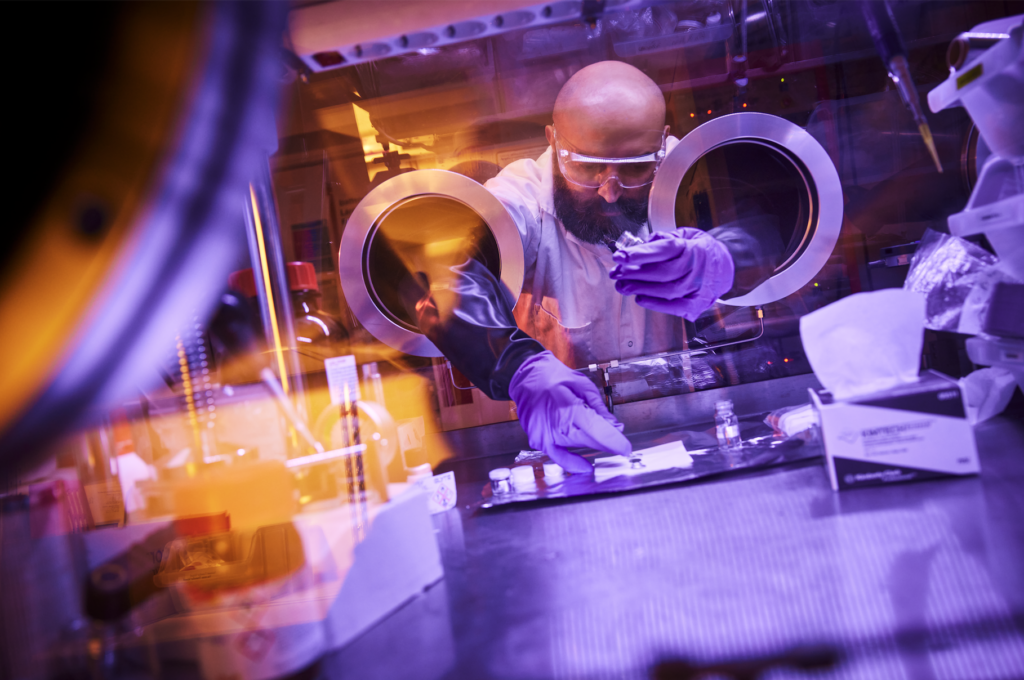 Portträtt av en manlig forskare in action i sitt labb, i lila ljus.